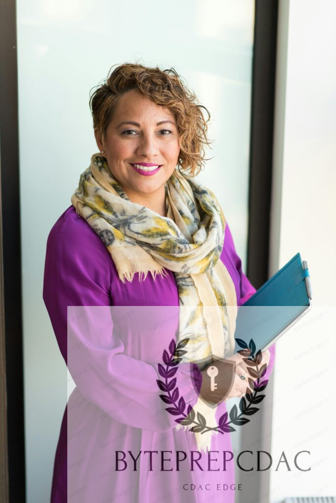Smiling woman in a purple dress and scarf holding a tablet indoors.